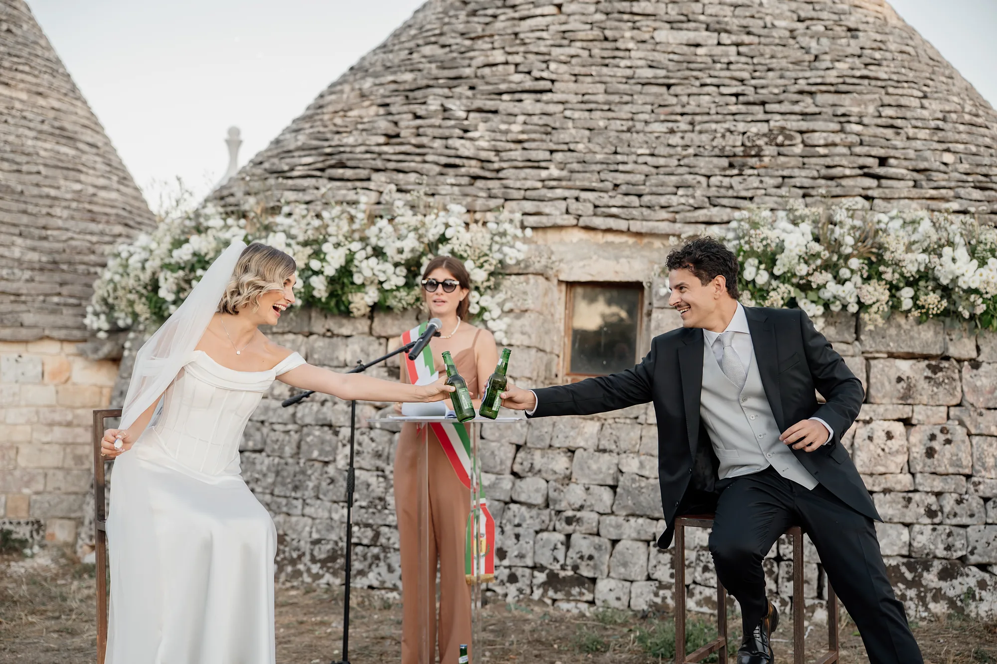 Cerimonia civile davanti a un trullo con arco di fiori bianchi