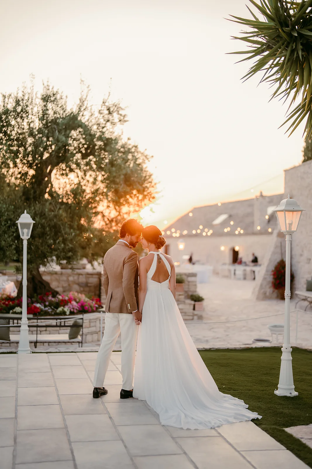 Sposi che si baciano al tramonto nel giardino di una masseria in Puglia