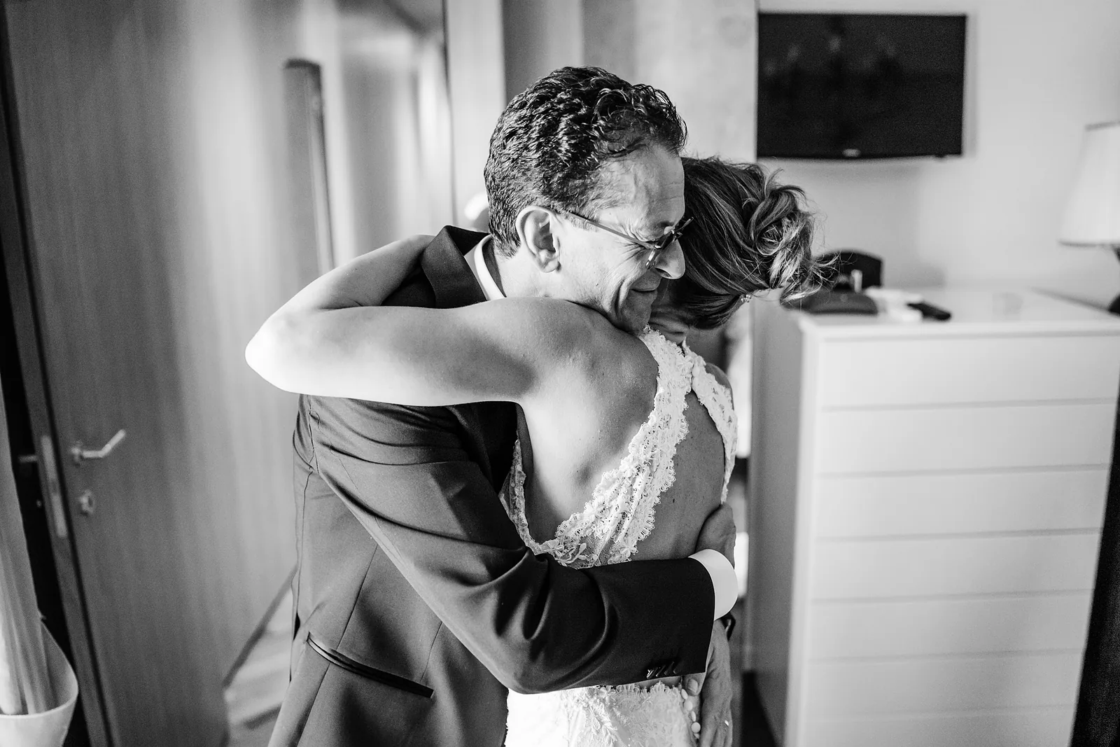 Il padre abbraccia la sposa durante i preparativi, in bianco e nero