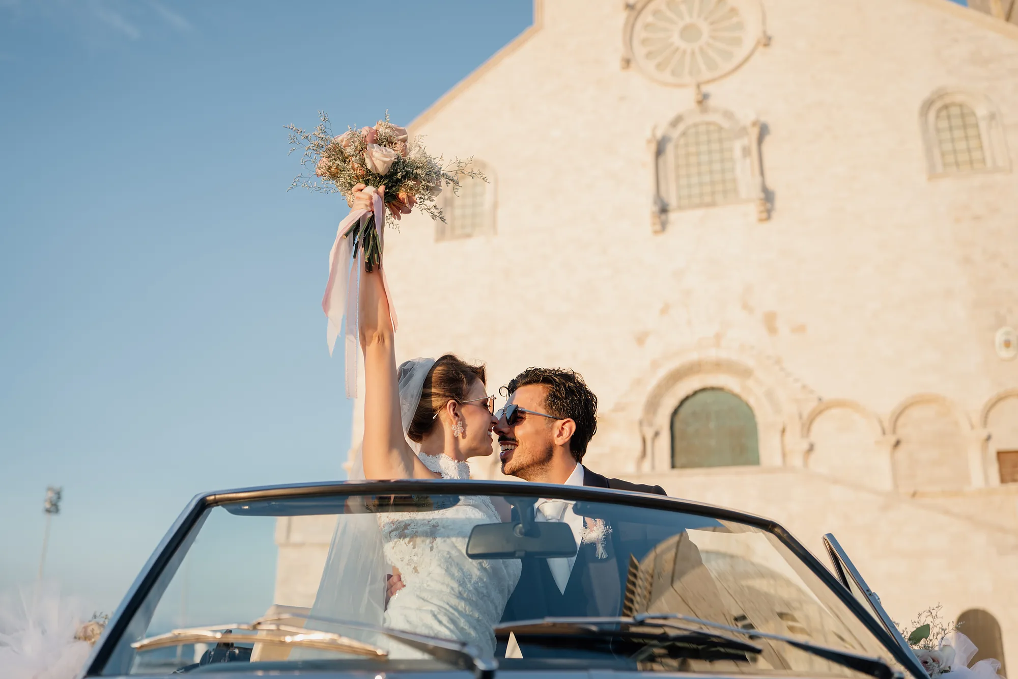 Sposi su un'auto d'epoca davanti alla cattedrale
